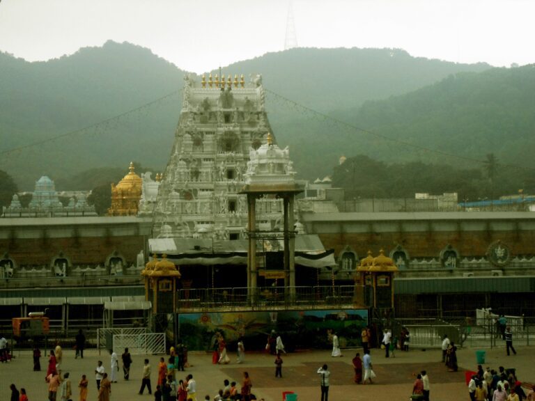 The white main gateway tower of the Tirumala Venkateswara temple, with a golden dome to its left, green hills behind and pilgrims crossing the forecourt (file photo)