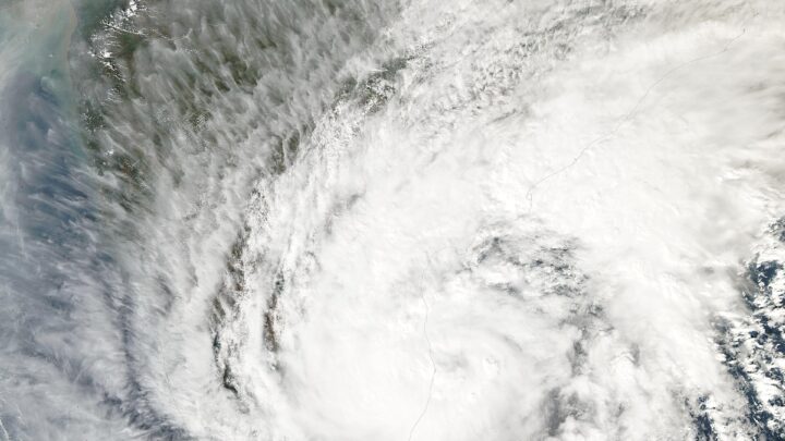 Satellite image of a large white swirl of cloud from a tropical cyclone over the Bay of Bengal, with the east coast of India visible beneath it.