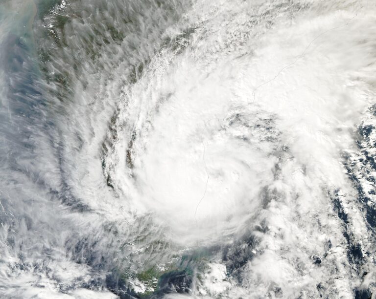 Satellite image of a large white swirl of cloud from a tropical cyclone over the Bay of Bengal, with the east coast of India visible beneath it.