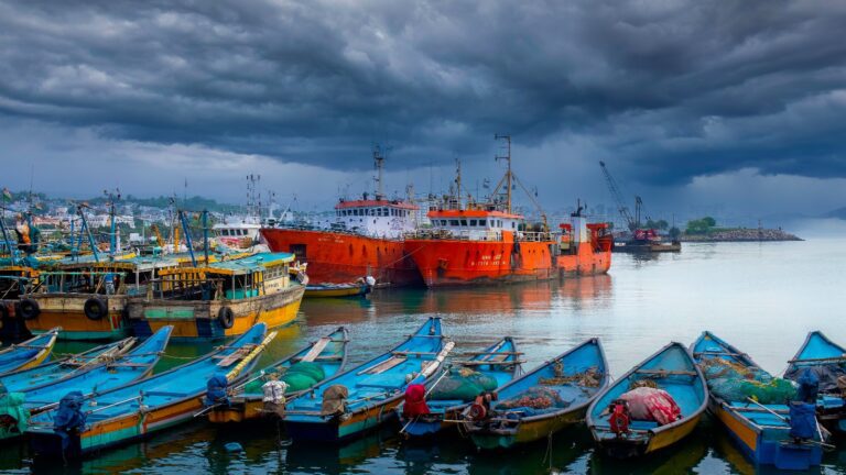 Fishing boats moored at Visakhapatnam fishing harbour under dark storm clouds