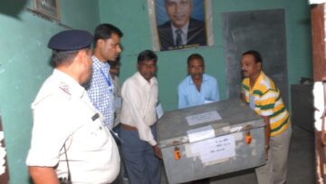 Election officials carrying a ballot box at a counting centre