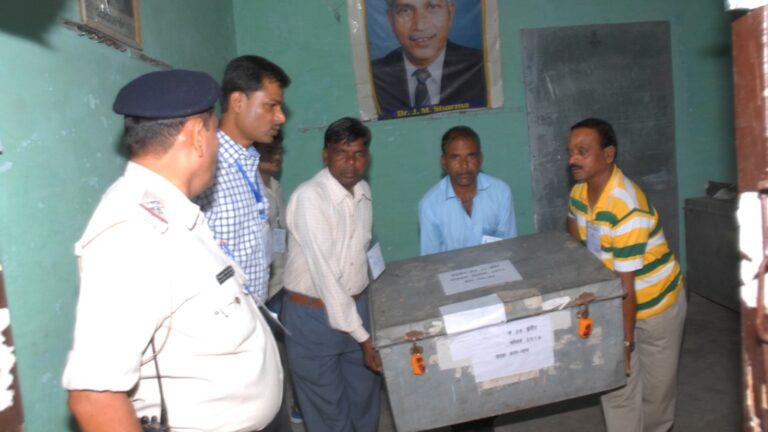 Election officials carrying a ballot box at a counting centre