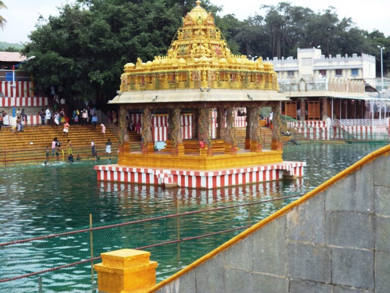 The gilded mandapam in the middle of Swami Pushkarini at Tirumala, with devotees on the steps of the tank.