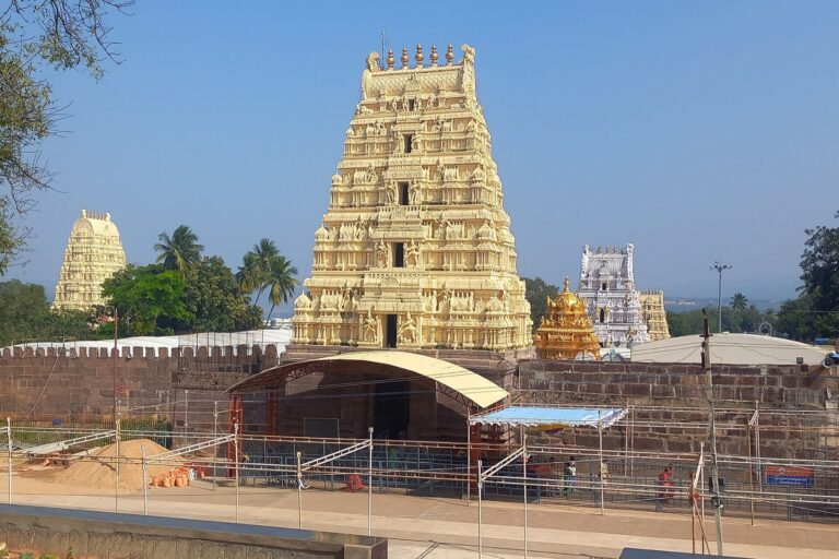 The west gopuram of the Srisailam temple, with smaller temple towers and queue barricades in front.