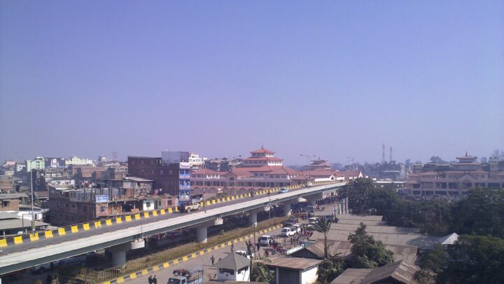 A flyover and market buildings in Imphal seen from above on a clear day.