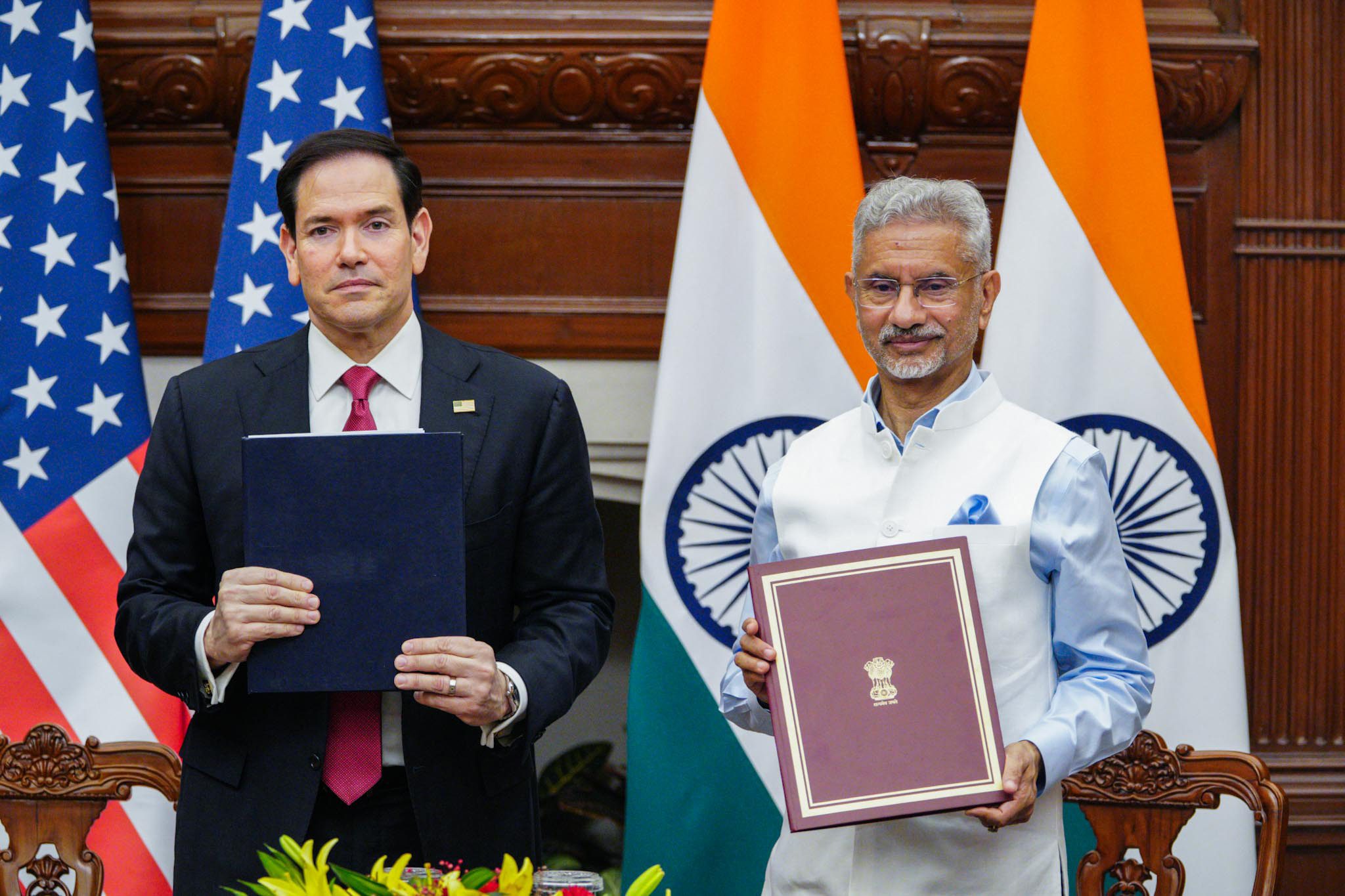 US Secretary of State Marco Rubio and External Affairs Minister S Jaishankar hold document folders in front of US and Indian flags