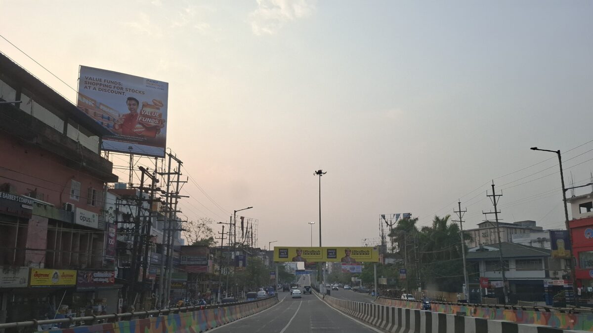 A road lined with shops and traffic in Guwahati city