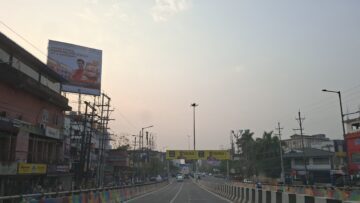 A road lined with shops and traffic in Guwahati city