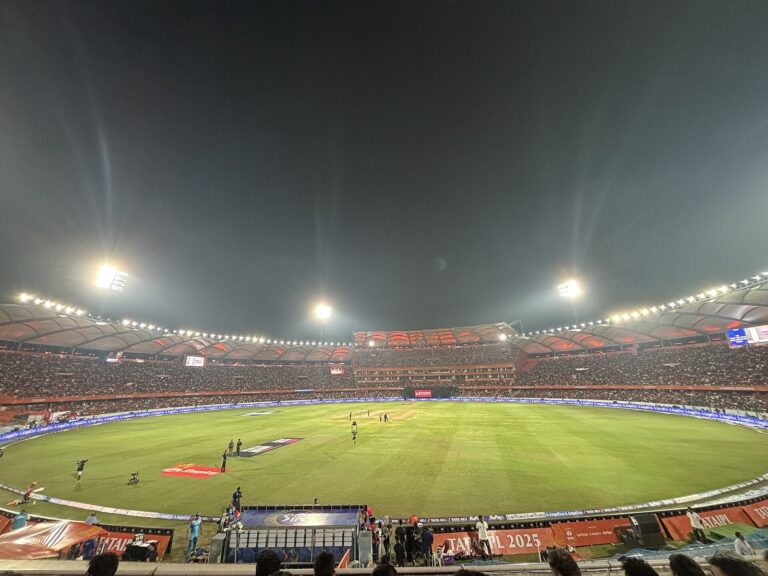 A packed, floodlit cricket stadium in Hyderabad during a night match.