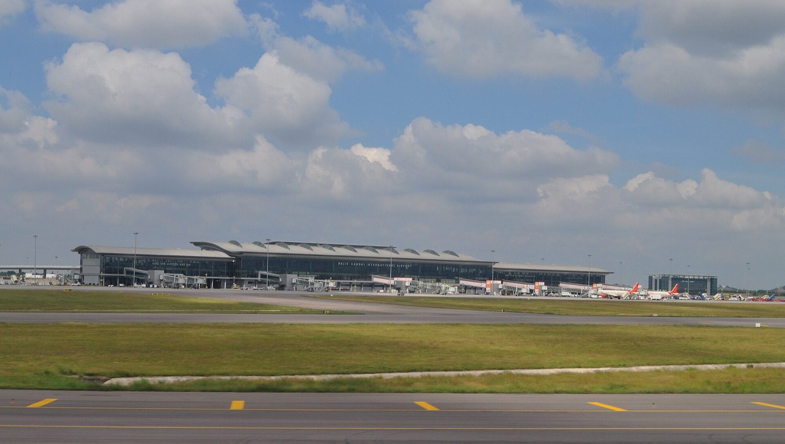 The terminal building of Rajiv Gandhi International Airport seen across the airfield, with aircraft parked at the gates.