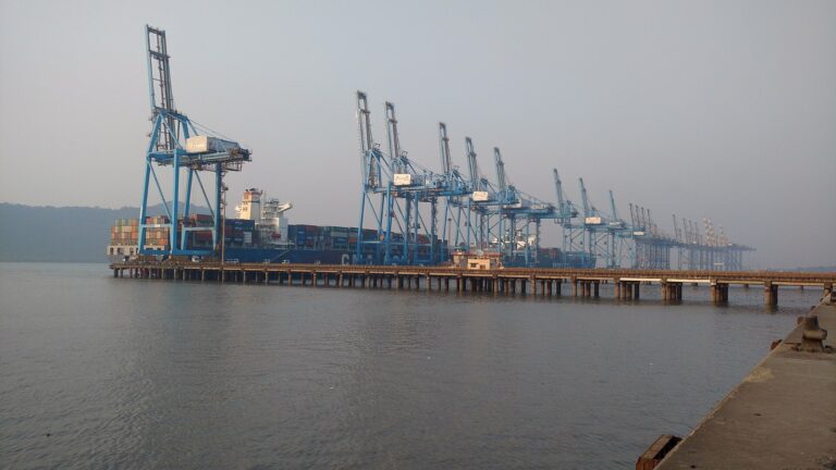 Container cranes and a docked container ship at Jawaharlal Nehru Port in Navi Mumbai.