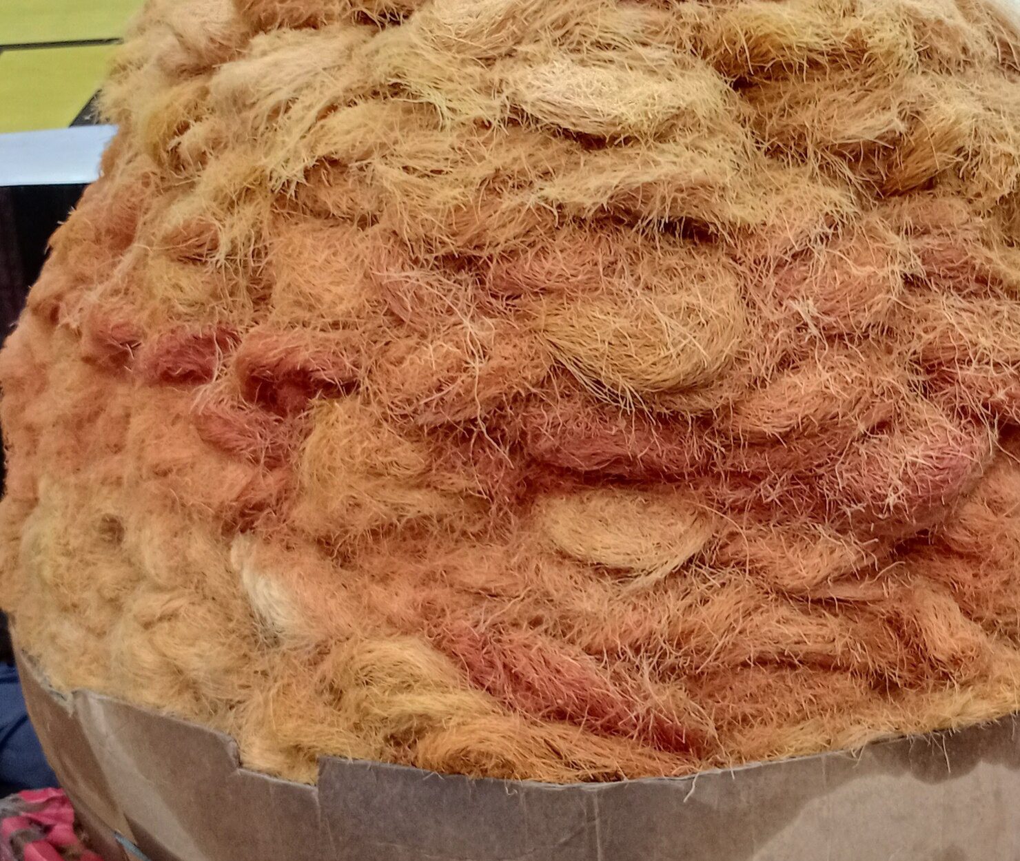 A large heap of loose pheni piled in a cardboard container at a market stall.