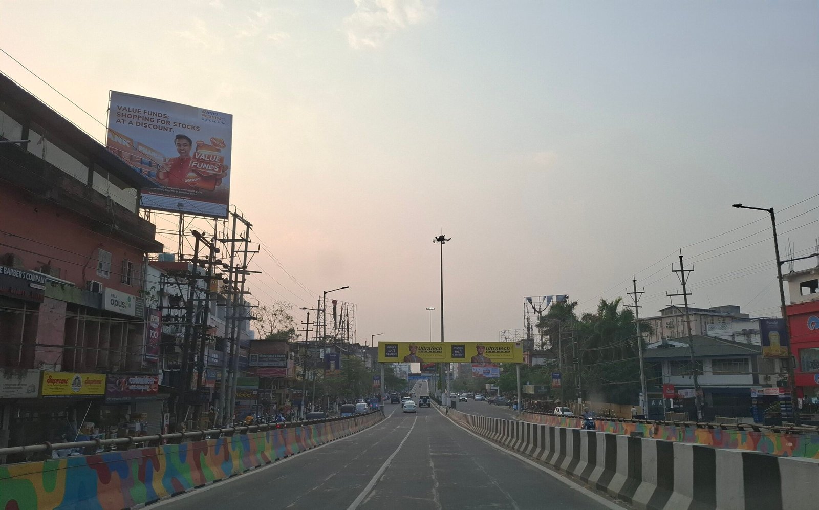 A road lined with shops and traffic in Guwahati city