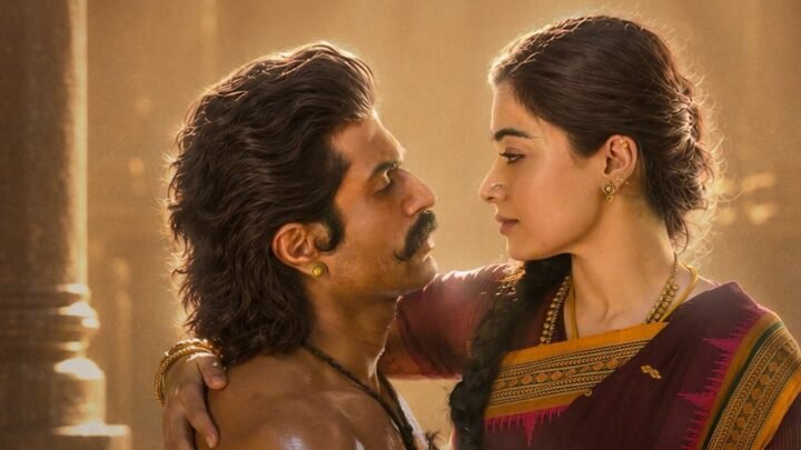 Vijay Deverakonda and Rashmika Mandanna, in period costume, face each other in a film still.